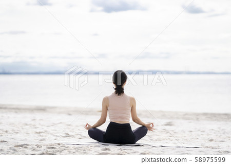 Yoga Meditation and relaxation on the sandy beach (Easy pose) 58975599
