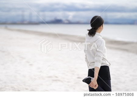 Women doing flexible exercises on the sandy beach 58975808