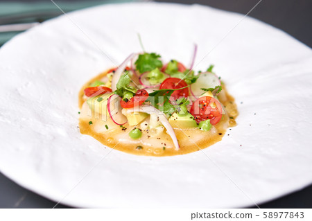 Tartar from scallop with avocado, cherry tomatoes, radishes and onion. Dish in the restaurant from Tartar from scallop with avocado, cherry tomatoes, radishes and onion. Dish in the restaurant from 58977843
