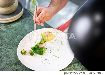 The chef serves the dish Salmon steak fillet and garnished with young broccoli. Restaurant menu, a 58977986