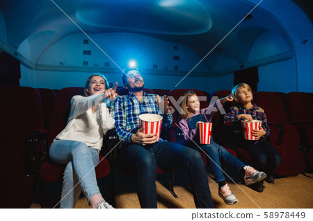 Young caucasian family watching a film at a movie theater 58978449