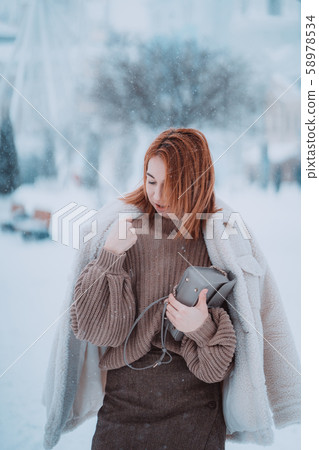 Woman outside on snowing cold winter day Woman outside on snowing cold winter day 58978534