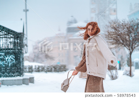 Woman outside on snowing cold winter day 58978543