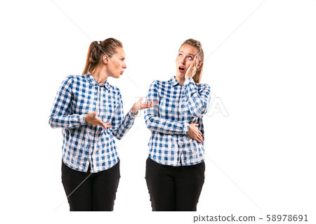Young handsome woman arguing with herself on white studio background. Young handsome woman arguing with herself on white studio background. 58978691