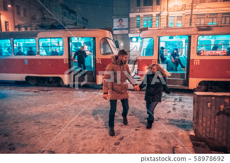 Young adult couple on snow covered tram station 58978692