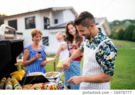 Portrait of multigeneration family outdoors on garden barbecue, grilling. 58978777