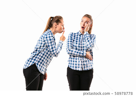 Young handsome woman arguing with herself on white studio background. 58978778