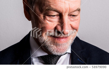 Close-up portrait of a senior man with beard and mustache in a studio. 58979090