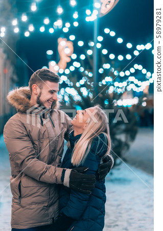 Outdoor close up portrait of young beautiful couple posing on street. 58979281