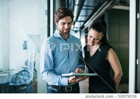 Young businesspeople with clipboard in an office, working. 58979338