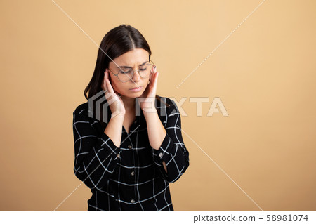 A young woman holding her temples. The girl has a headache. A young woman holding her temples. The girl has a headache. 58981074
