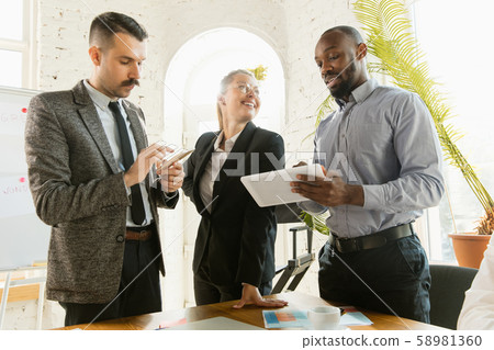 Group of young business professionals having a meeting, creative office Group of young business professionals having a meeting, creative office 58981360