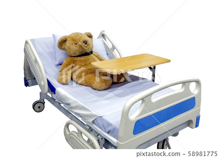 Brown teddy bear lying sick in bed 58981775
