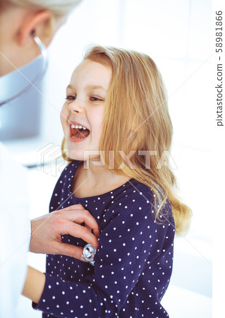 Doctor examining a child patient by stethoscope. Cute baby girl at physician appointment. Medicine Doctor examining a child patient by stethoscope. Cute baby girl at physician appointment. Medicine 58981866