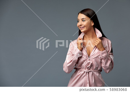 Girl in pink overalls poses for the camera on a gray background. Isolate, copy space. 58983068