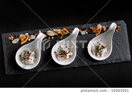 Sea bass ceviche mini portions served in beautiful Chinese spoons on a black plateau. Food concept 58983091