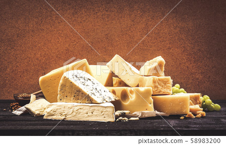 Different types of cheese on black wooden table background 58983200