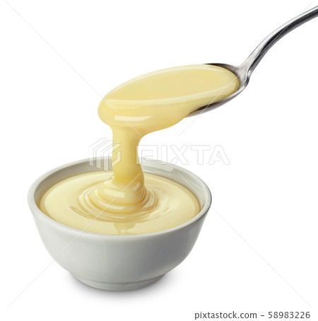 Pouring condensed milk isolated on white background 58983226