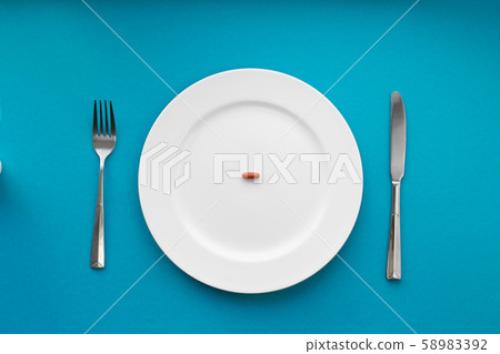 A small tablet in a plate. Medical concept. Eat A small tablet in a plate. Medical concept. Eat 58983392