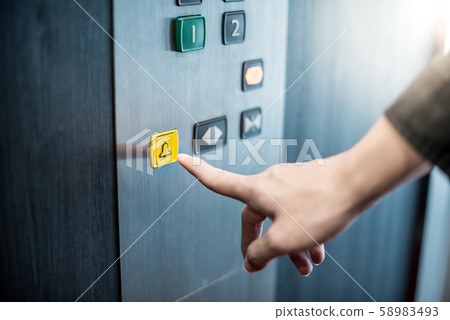 Male hand pressing on emergency button in elevator Male hand pressing on emergency button in elevator 58983493