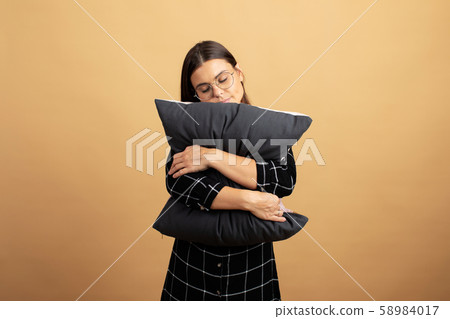 A young woman hugs a pillow and is very happy. Young woman 58984017