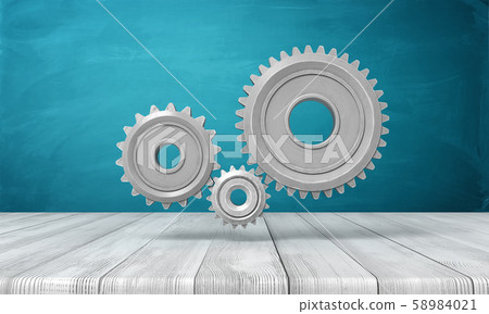 3d rendering of light-grey metal gearwheels on wooden surface on blue wall background. 3d rendering of light-grey metal gearwheels on wooden surface on blue wall background. 58984021