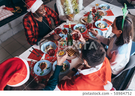 People sit at a festive table and celebrate new year's eve or Christmas. 58984752