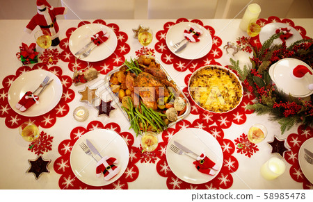 Christmas dinner at fire place and Xmas tree. 58985478