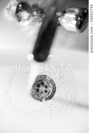 clear water drains into the drain hole of the sink 58985744