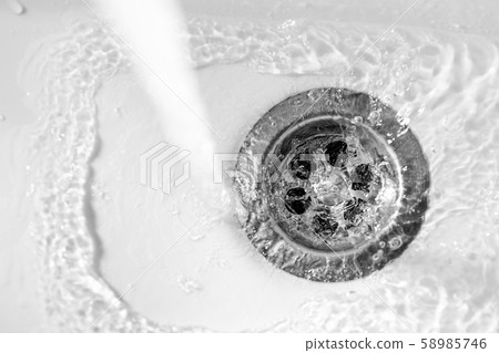 clear water drains into the drain hole of the sink 58985746