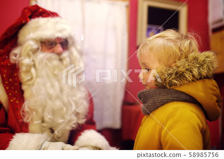 Little boy talking with Santa Claus on Christmas fair 58985756