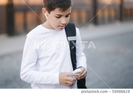 Teenage boy use wireless headphones for listening music 58986628