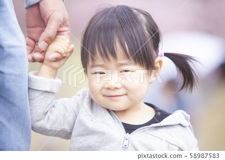 Child holding hands with mom 58987583