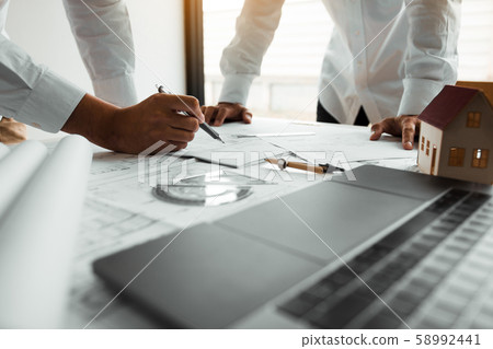 Engineering man showing blueprint detail for 58992441