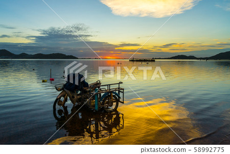 motercycle parked on the waterfront with sunset at motercycle parked on the waterfront with sunset at 58992775