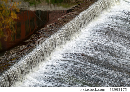 A small flat cascade in a calm river A small flat cascade in a calm river 58995175