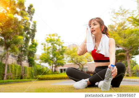 Asian girl relax and drinking after running in her Asian girl relax and drinking after running in her 58995607