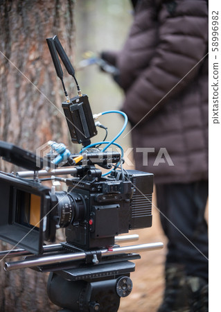 Camera is standing in the middle of the forest near the man 58996982