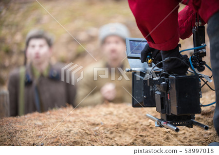 A man with camera in hand is filming the actors A man with camera in hand is filming the actors 58997018