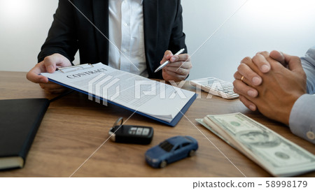 agent broker man holding document showing an agent broker man holding document showing an 58998179