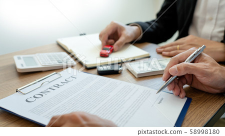 agent broker man holding document showing an agent broker man holding document showing an 58998180