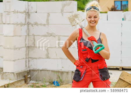 Woman using shovel on constriction site Woman using shovel on constriction site 58998471