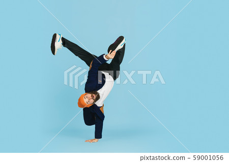 Businessman having fun dancing break dance on blue background at work Businessman having fun dancing break dance on blue background at work 59001056