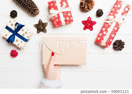 Top view of female hand holding an envelope on Top view of female hand holding an envelope on 59001121