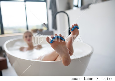 Close up of woman feet chilling in bath in the morning Close up of woman feet chilling in bath in the morning 59002158