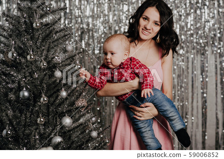 Mom and little baby boy on Christmas tree background 59006852
