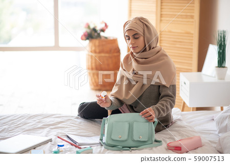 Pretty woman sitting on the bed filling thoughtful 59007513