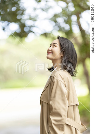 Cool woman in a bright smiling trench coat 59011849