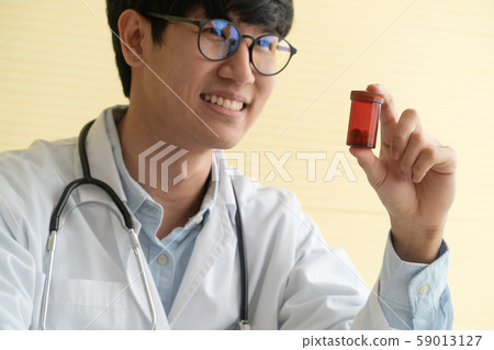 Asian doctor with stethoscope and uniform holding Asian doctor with stethoscope and uniform holding 59013127