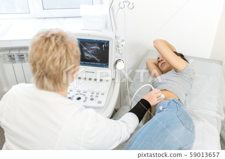 The doctor conducts an ultrasound diagnosis of the 59013657